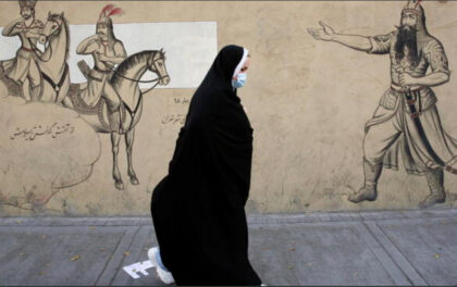 Donna con velo passa di fronte ad un murale. L'Iran abolisce la polizia morale e rivede l'obbligo del velo