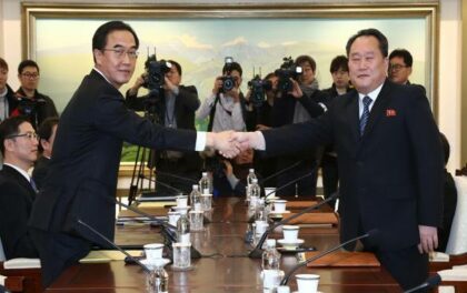 La Corea del Nord apre agli Usa. Nella foto delegati del Sud e del Nord si stringono la mano